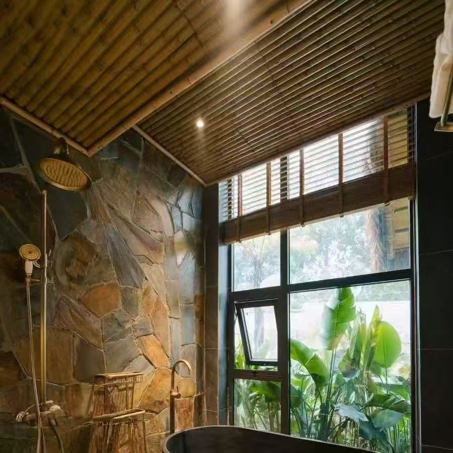 Bamboo ceiling ideas for a tropical bathroom with stone walls and large windows